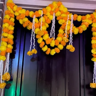 Artificial marigold garland hanging on decorated main door entrance